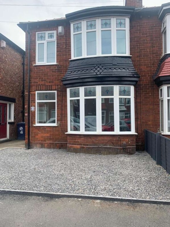 A two-story brick house with a bay window and a black roof. - A fabulous home in Redcar (Redcar)