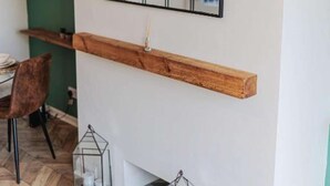 A dining area with a wooden shelf, a mirror, and two glass candle holders on the floor. - Comfortable home in Redcar (Redcar)