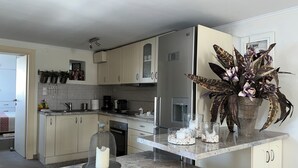 A modern kitchen with light-colored cabinets, stainless steel appliances, and a marble countertop. - In the heart of Poros, stunning panoramic views, privacy and serenity. (Poros)