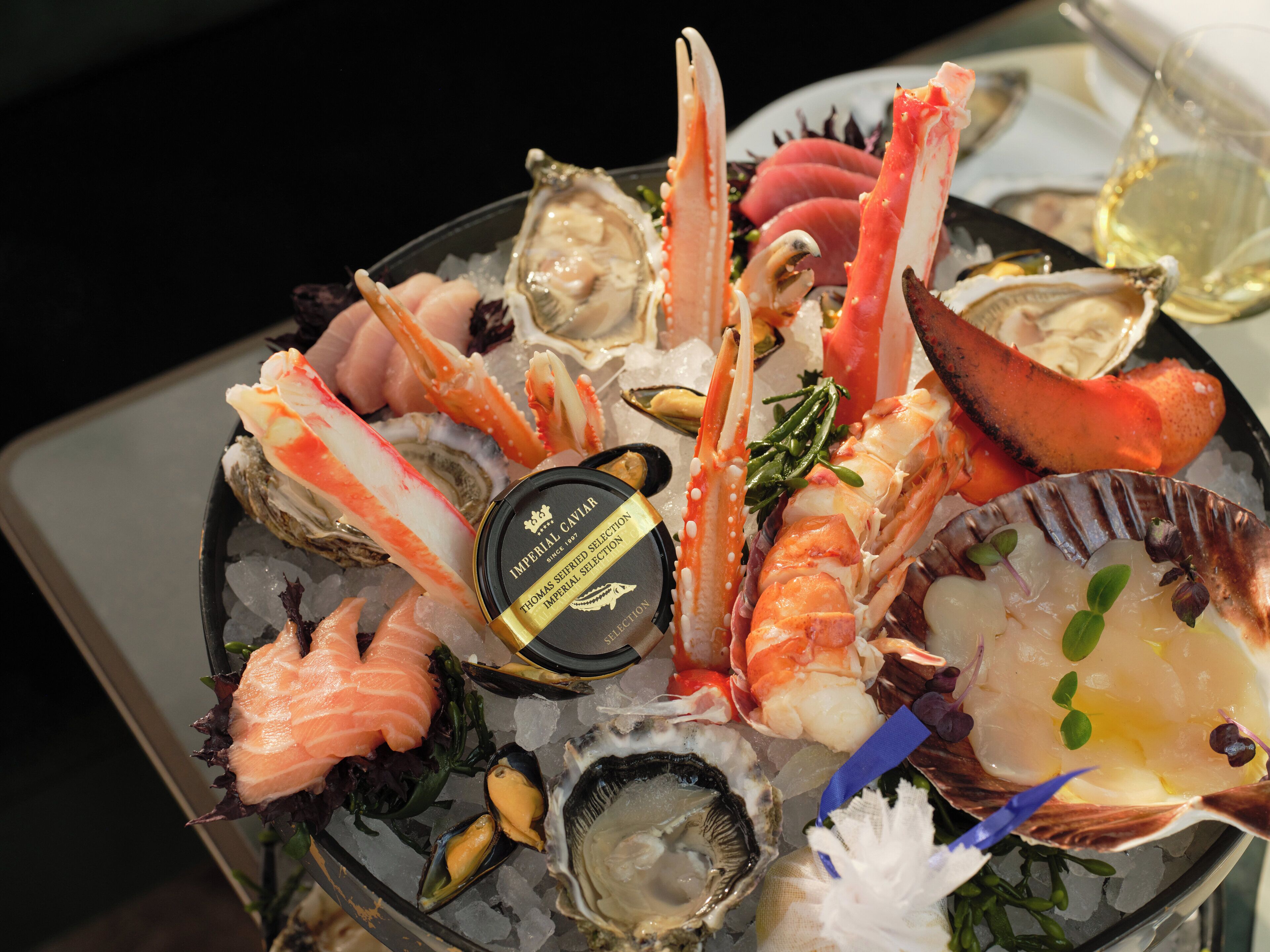 A seafood platter with various types of shellfish and a selection of oysters on ice.