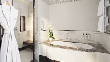 A modern bathroom with a large bathtub, a glass shower enclosure, and a marble vanity.