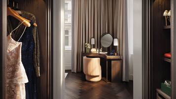 Ein Hotelzimmer mit einem Holzschrank, einem Schminktisch mit Spiegel und einem Fischgrätparkett.