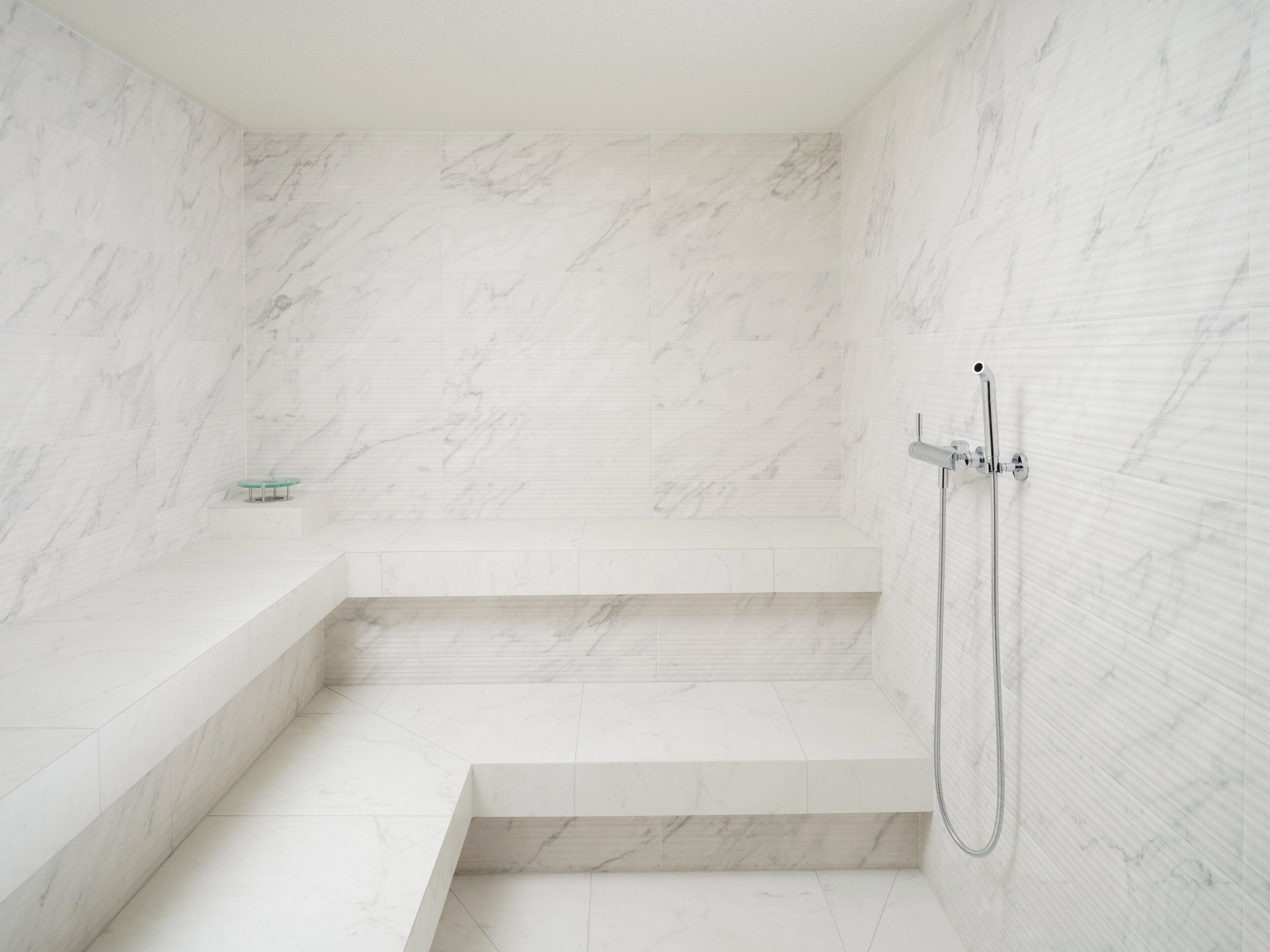 Une salle de bain moderne avec des murs en marbre et un espace douche.