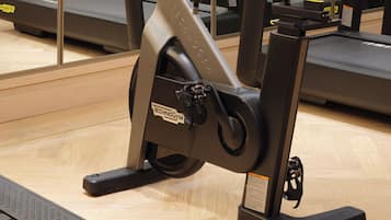 A gym with stationary bikes, treadmills, and a mirrored wall.