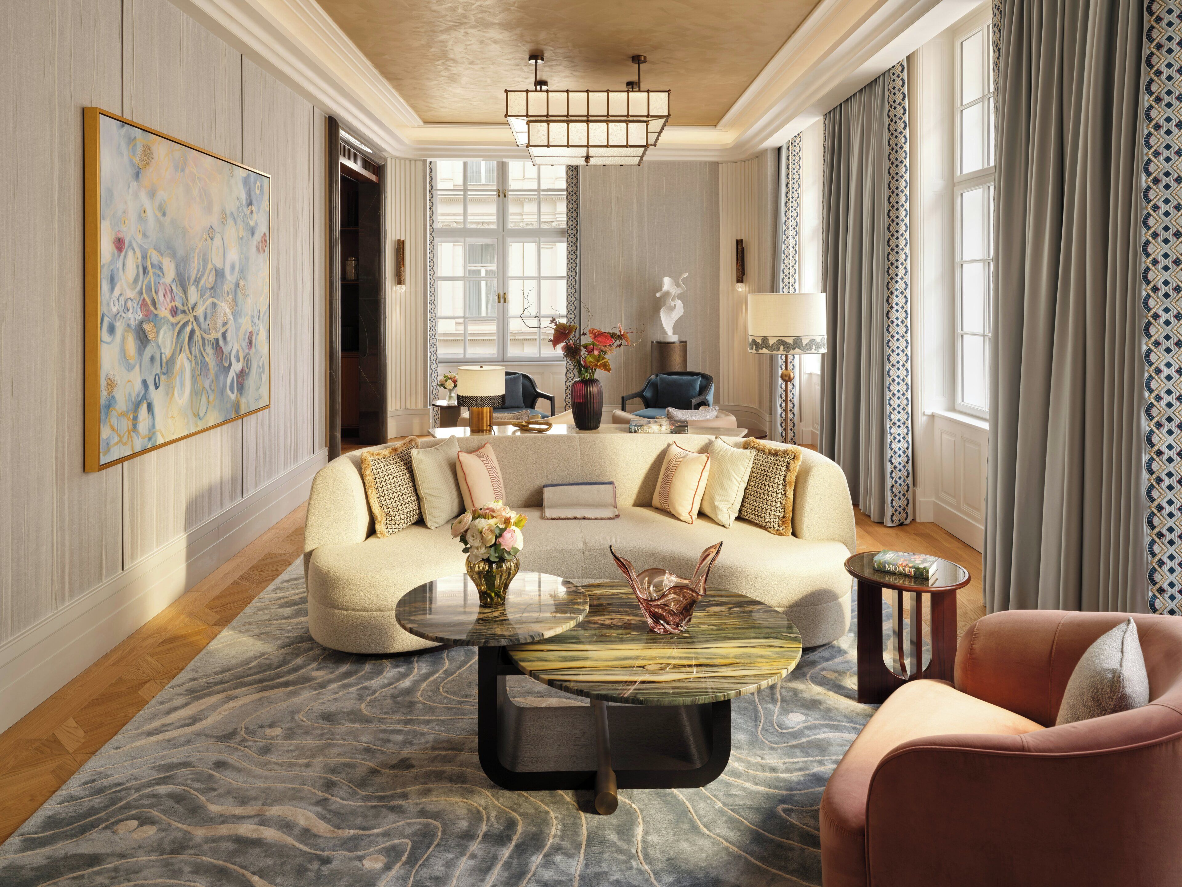 Un salón espacioso con un sofá grande, una mesa de centro y un sillón rosa.