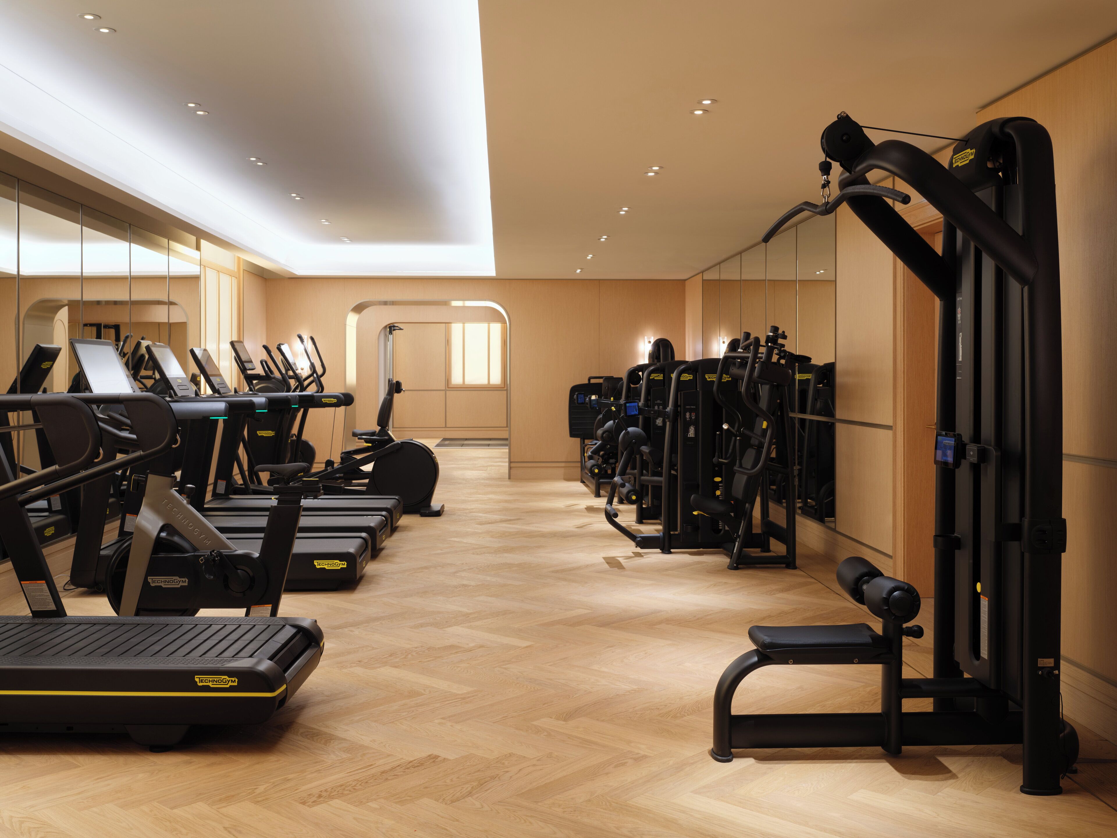 Una palestra con tapis roulant, macchinari ellittici e macchine per pesi.