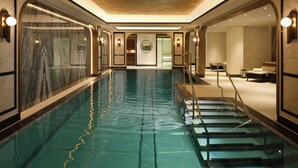A luxurious indoor swimming pool with marble walls, a clear blue pool, and a modern design. - Mandarin Oriental, Vienna (Vienna)