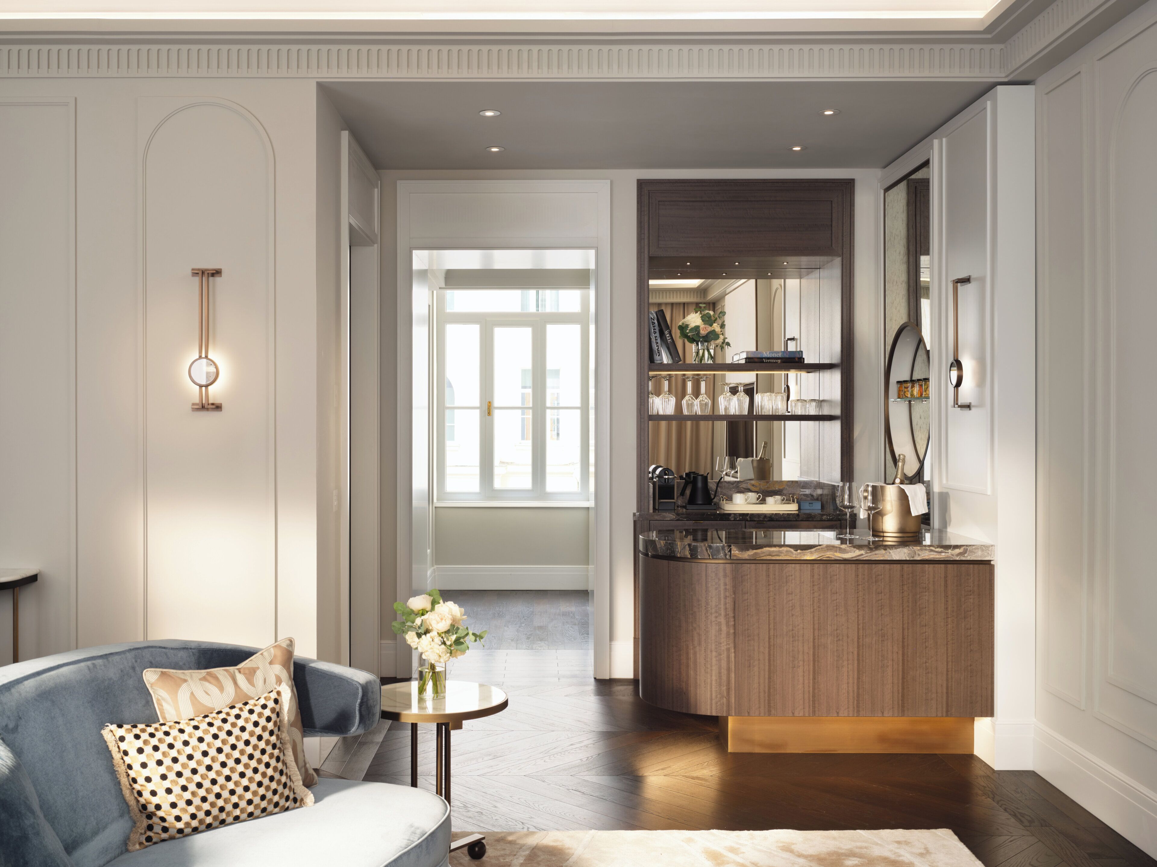 Een moderne woonkamer met een bank, salontafel en een keukenhoek met houten kasten en een aanrecht.