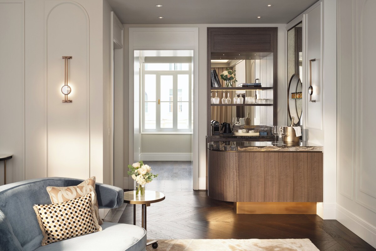 Un salon moderne comprenant un canapé, une table basse et un coin cuisine avec des meubles en bois et un plan de travail.
