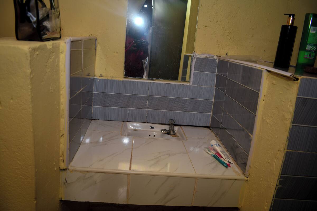 A bathroom with a sink, mirror, and toiletries.