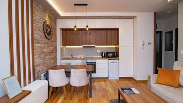 A modern kitchen with wooden cabinets, a brick accent wall, and pendant lighting.