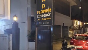 A sign for 'Wind Flower Residency A/c Rooms' with a red car parked nearby. - WIND FLOWER (Mumbai)