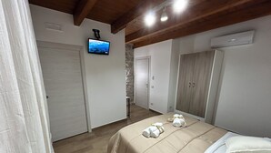 Ein Schlafzimmer mit Bett, Fernseher und Kleiderschrank.