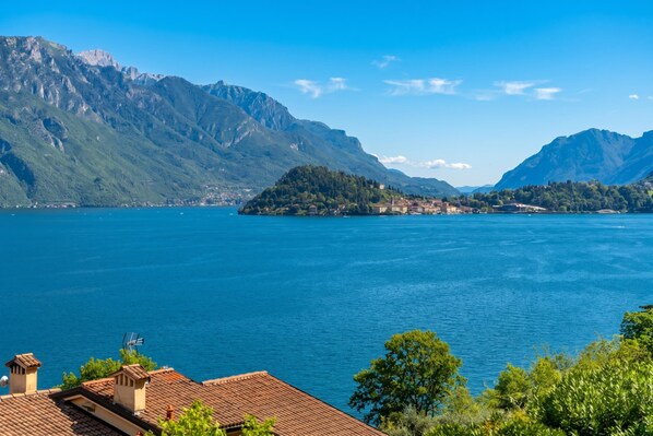 A lake with mountains in the background and a small island with buildings.
