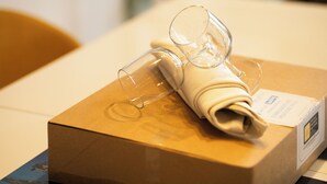 A cardboard box with a rolled-up towel and a pair of glasses on top. - Casa Mia Menaggio (Menaggio)