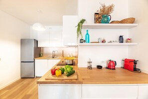A modern kitchen with a wooden countertop, a stainless steel refrigerator, and a red Bosch coffee maker. - Casa Mia Menaggio (Menaggio)
