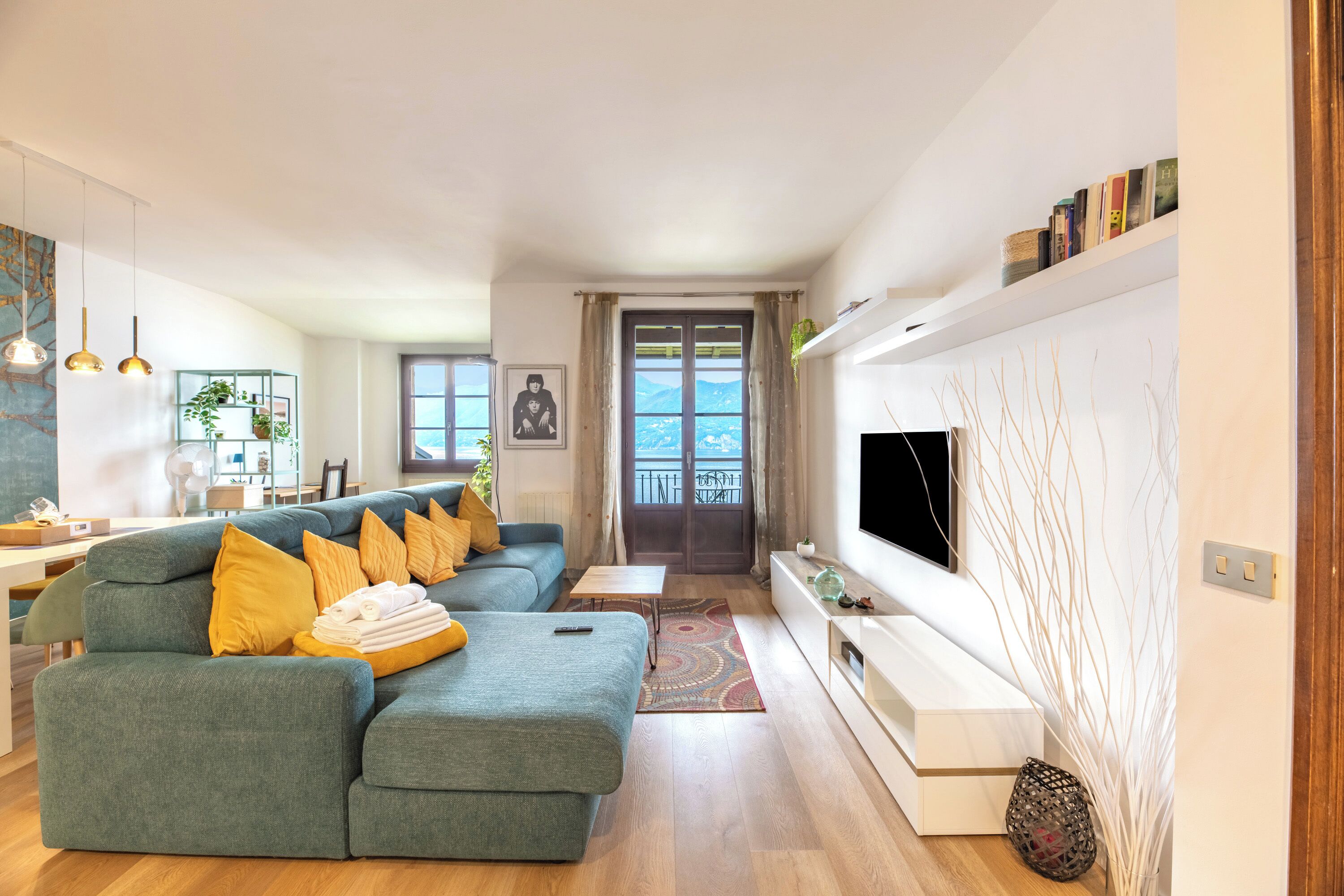 Una sala de estar moderna con un sofá, televisor y vistas al exterior.