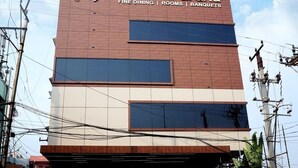 Hotel Nayeena Grand with a modern facade, featuring a signboard with the hotel's name and services like fine dining, rooms, and banquets. - Hotel Naveena Grand (Hyderabad)