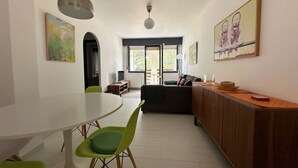 Un espacio habitable moderno con zona de comedor, sofá y mostrador de cocina.