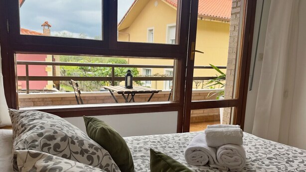 Une chambre d’hôtel avec un lit, des oreillers et une vue sur le balcon extérieur.