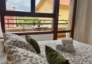 Une chambre d’hôtel avec un lit, des oreillers et une vue sur le balcon extérieur.