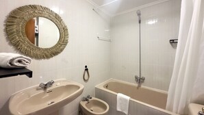 Une salle de bain équipée d’un lavabo, d’un bidet, d’une baignoire et d’une douche.