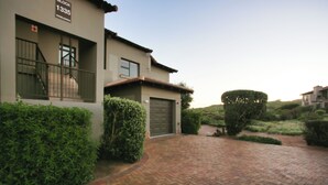 A modern two-story house with a brick driveway, a gated garage, and well-maintained hedges. - Francolin's Nest, Langebaan, 4-sleeper (Langebaan)