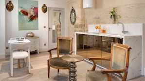 A modern kitchen with a marble countertop, a sink, and a vase with flowers. - Cloître des Augustins 5 étoiles, Spa & Fitness (Avignon)