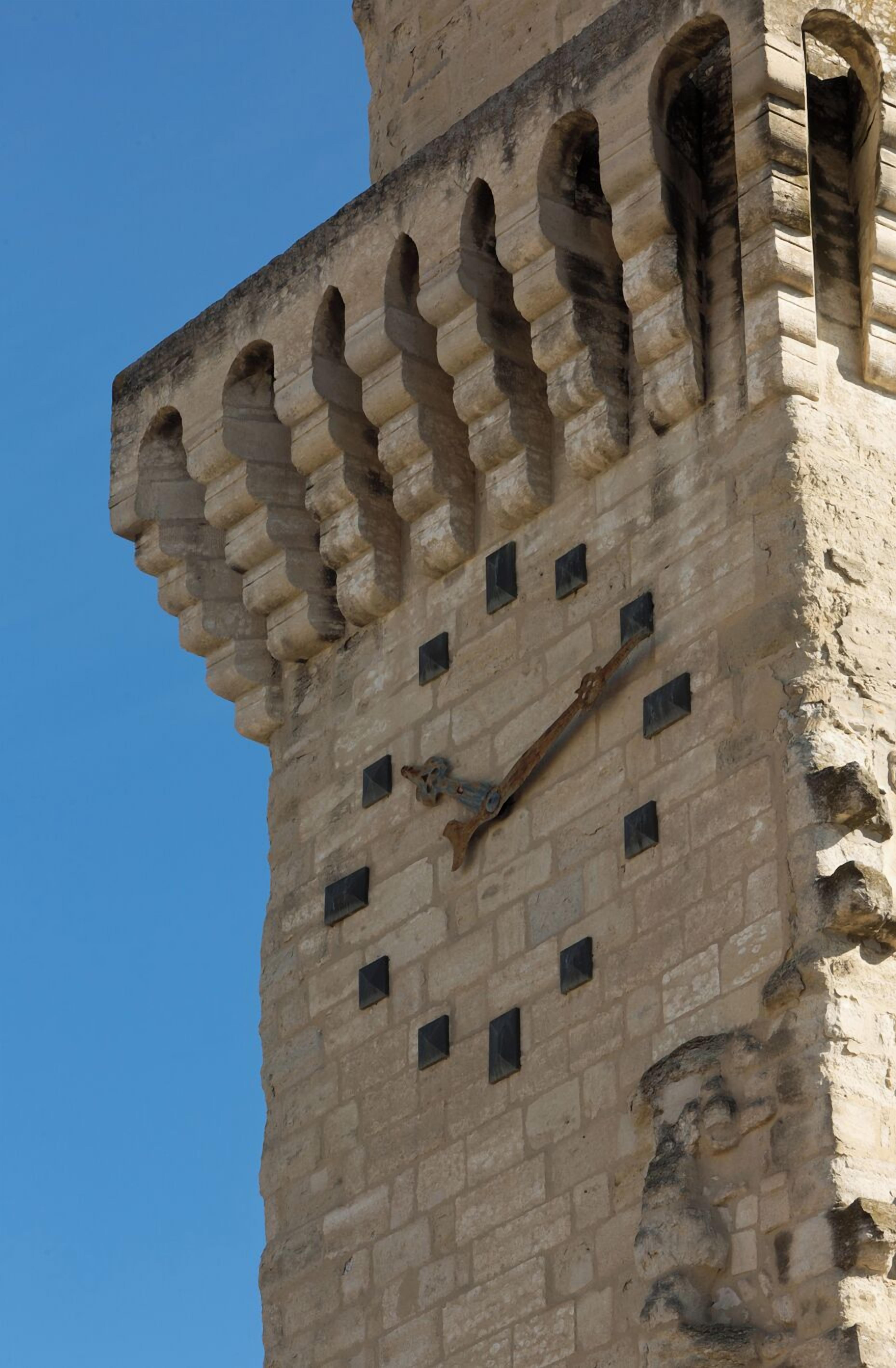 Una alta torre de piedra con una serie de ventanas en arco y una escalera en espiral.