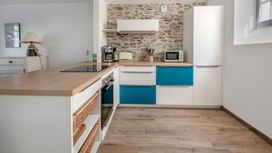 A compact kitchen with a stone backsplash, a microwave, and a coffee maker. - Close to port & beaches - Terrace - House for 5 (Pornic)