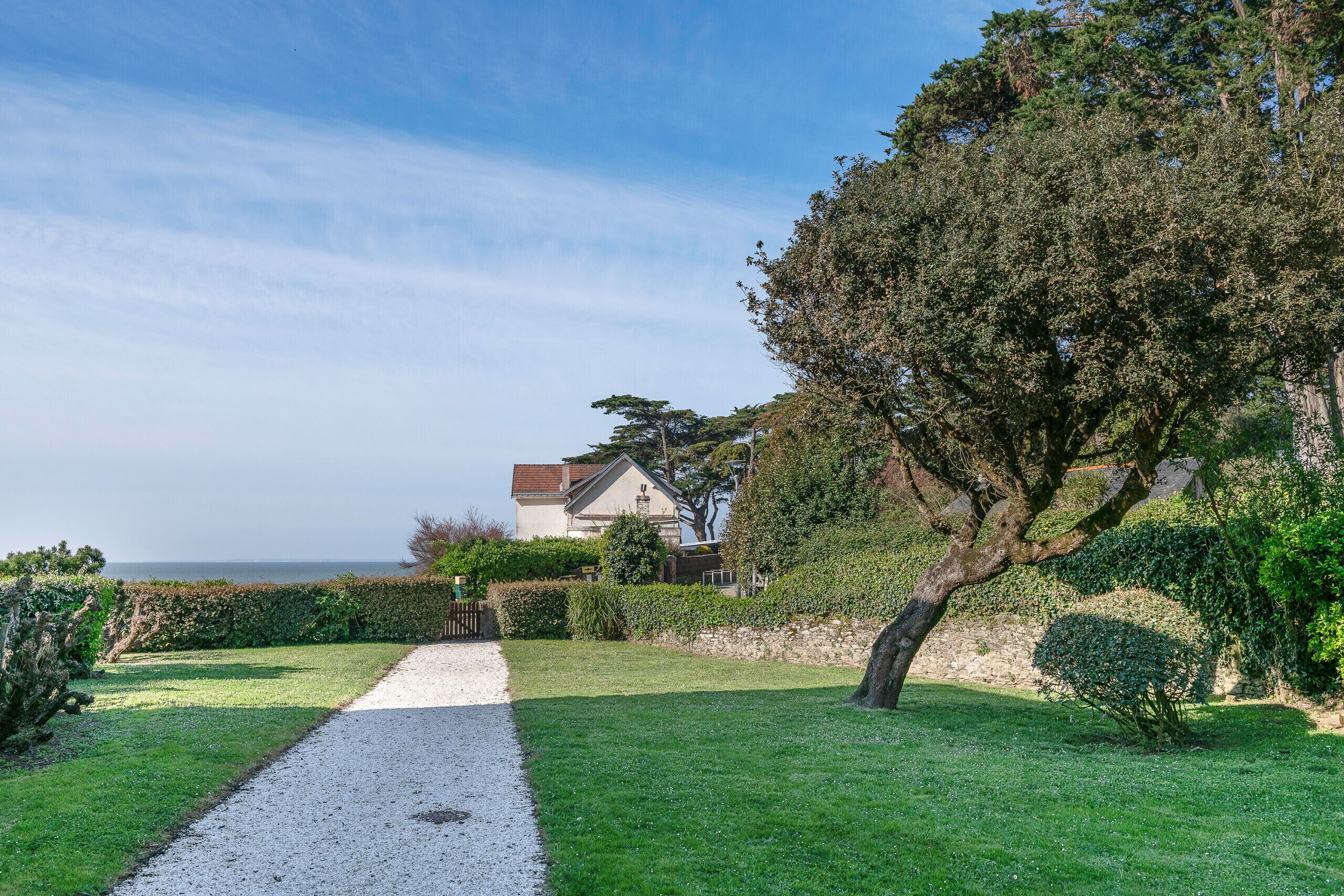 A pathway leading to a house with a view of the sea.