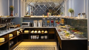A breakfast buffet with various food items and a coffee station.