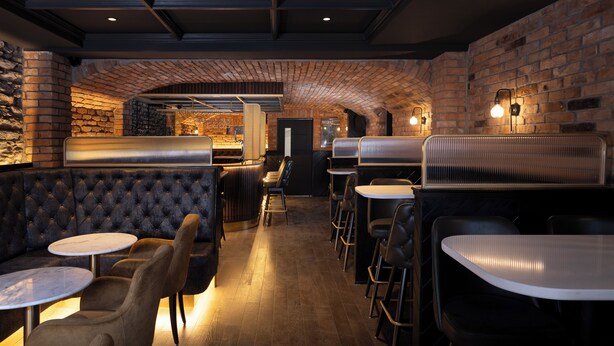 A restaurant with brick walls, wooden floors, and a bar area. - House 15 (Kenmare)