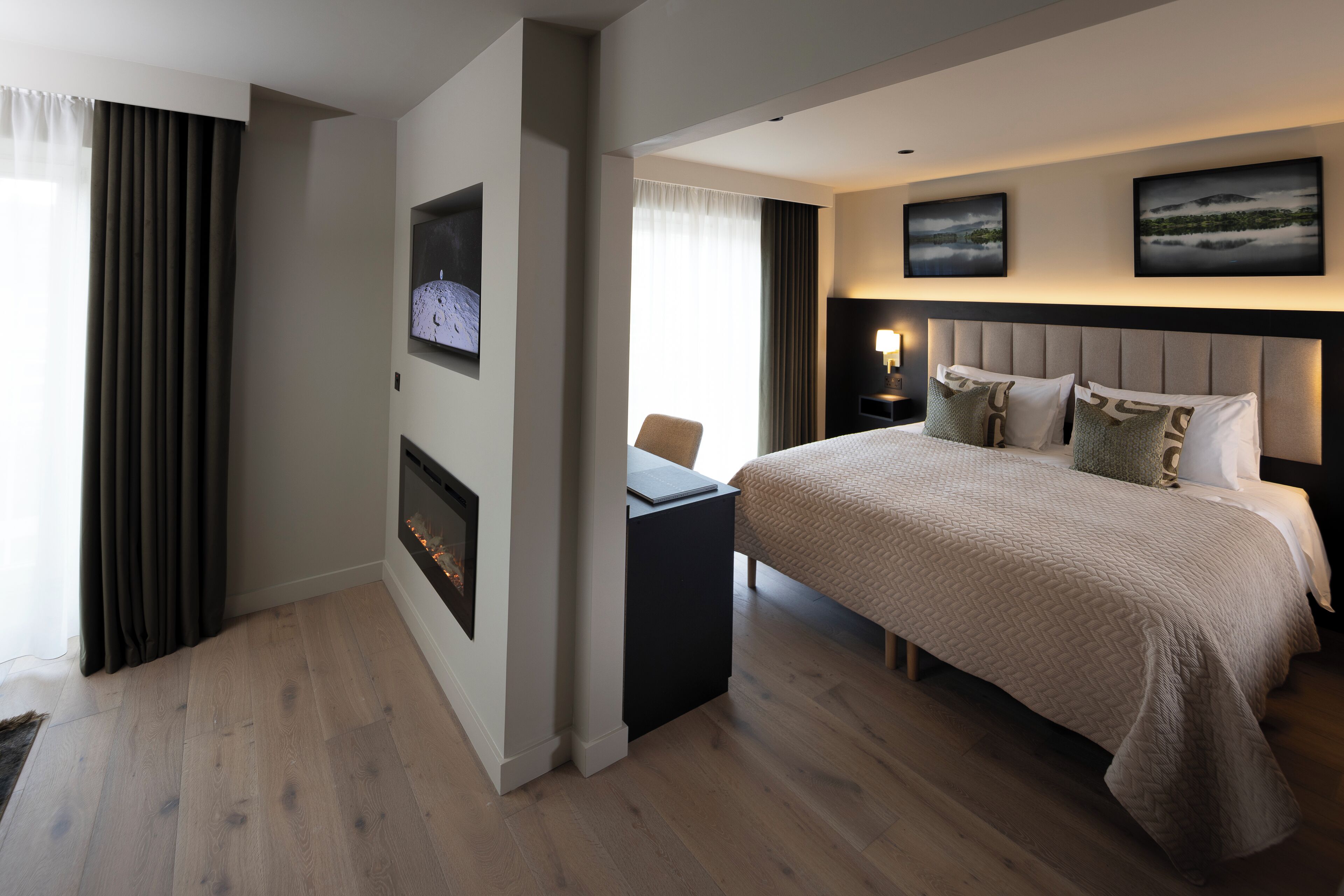 Una habitación de hotel moderna con una cama grande, un escritorio y una chimenea.