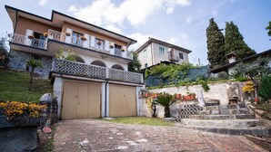 A residential building with a gated entrance, a balcony with potted plants, and a stone staircase leading up to a second-floor building. - LA VILLETTA DEL NONNO BORTOLO (Castello)