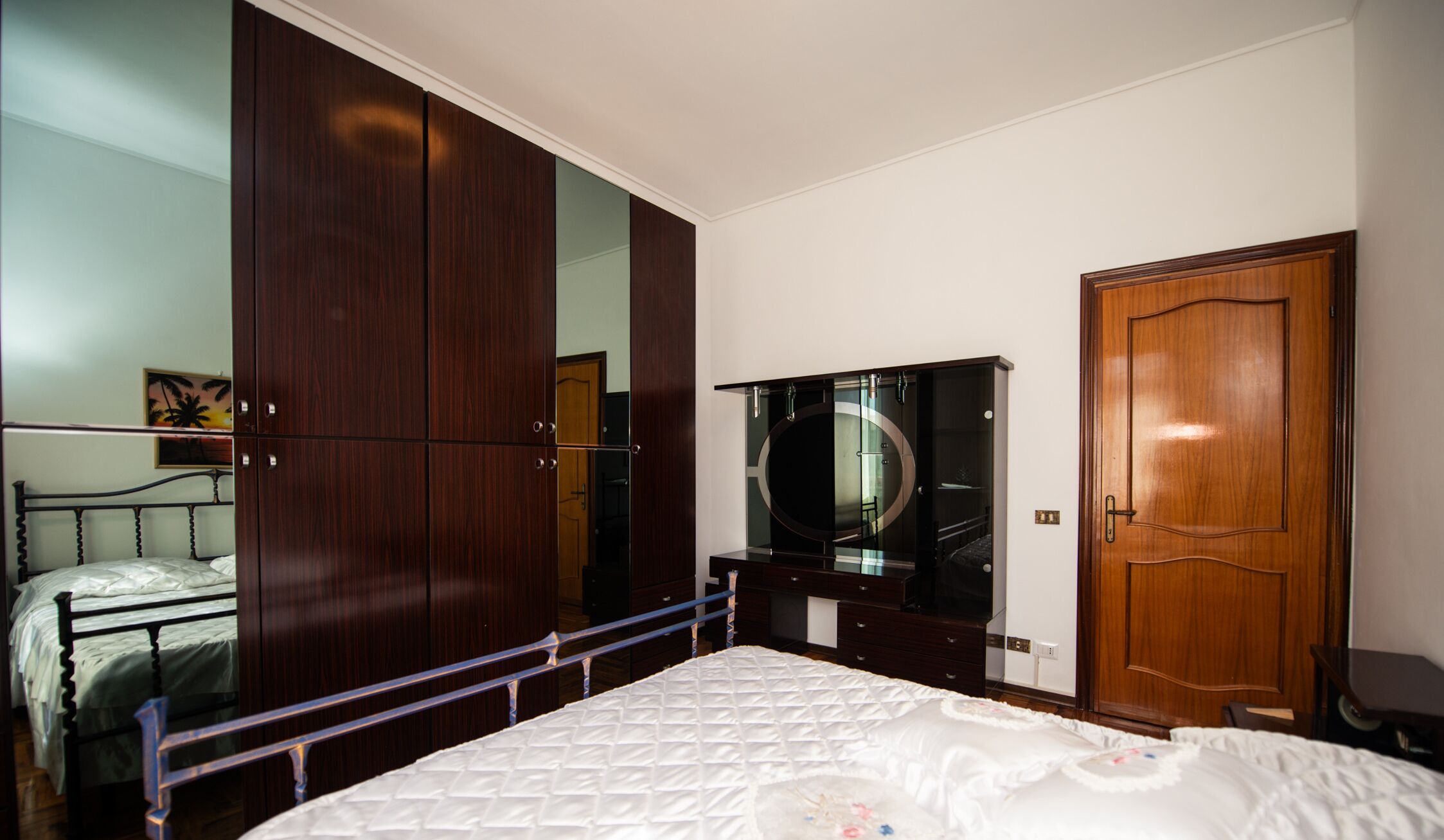 A bedroom with a bed, wardrobe, and a TV.