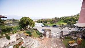 A paved driveway leading to a gated entrance with a white fence, a parked caravan, and cars. - La Villetta del Nonno Bortolo (Castello)