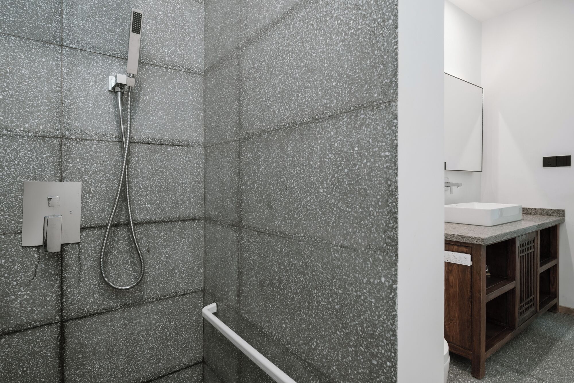 Un baño con ducha, lavamanos y espejo.
