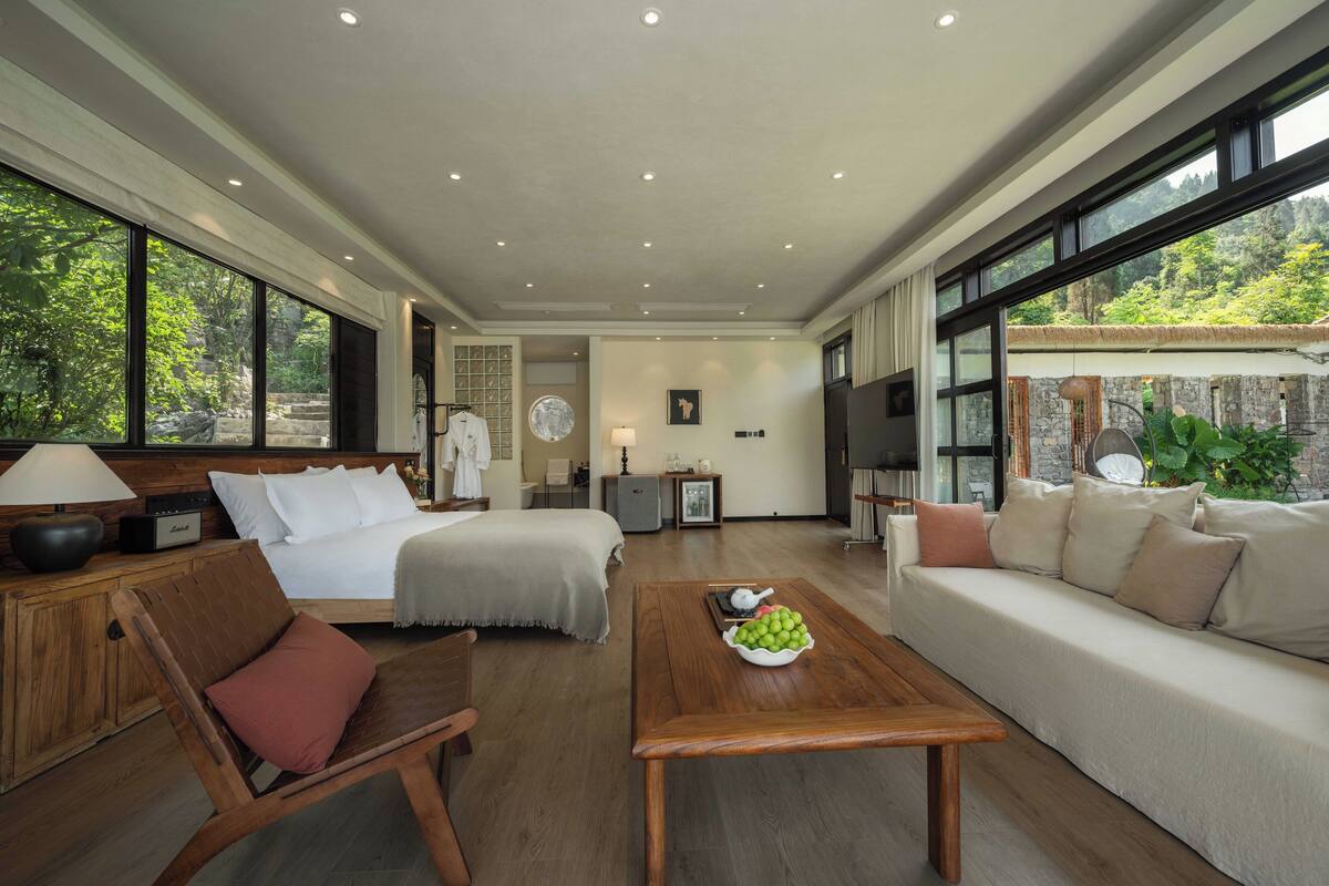 Ein geräumiges Wohnzimmer mit einer großen Couch, einem Holztisch und einer gemütlichen Sitzecke.
