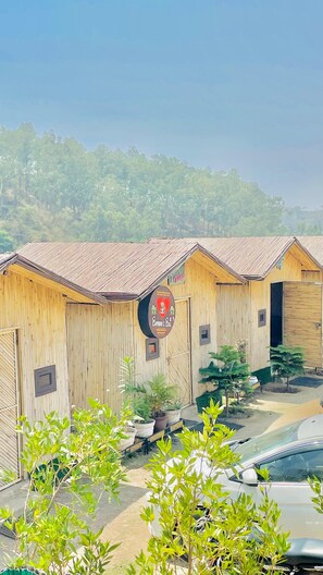 A row of wooden cabins with a sign indicating a restaurant. - Bambooz Bel cottage and camps Kasauli (Kasauli)