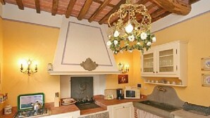 Une cuisine équipée d’une cuisinière, d’un four et d’un lustre.