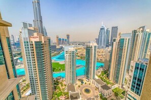A high-rise building with a prominent "RAMADA" sign, surrounded by other tall buildings and a central water feature.