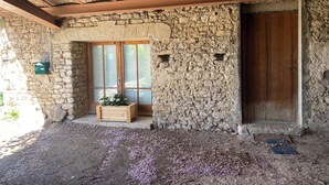 A rustic stone building with a wooden door and a window with frosted glass. - La Maison Rose, family vacation home (Lagnes)