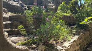 A stone staircase leading up a rocky hillside, surrounded by lush greenery and trees. - La Maison Rose, family vacation home (Lagnes)
