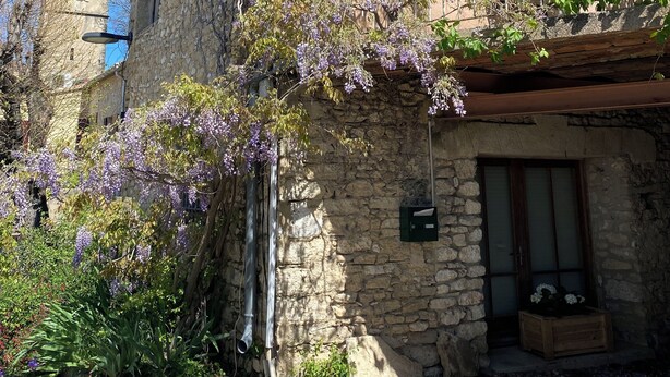 A stone building with a bell tower, a balcony with blue shutters, and purple flowering vines. - La Maison Rose, family vacation home (Lagnes)