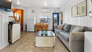 A compact living space with a kitchenette, a dining area, and a sofa. - Charming 2-Bedroom Getaway A/C, WIFI, Covered porch just 3 Minutes to the Beach! (Hampton)