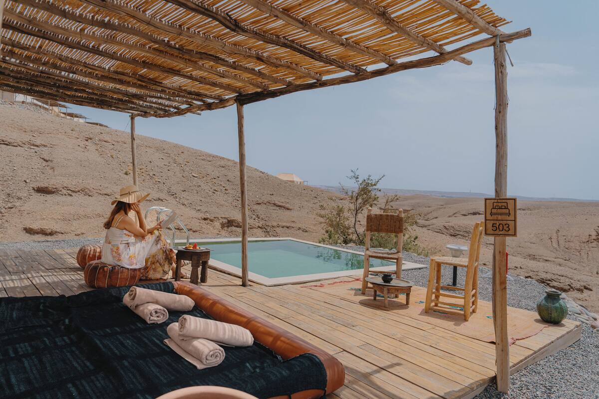 A wooden deck with a pool, a lounge chair, and a sign with the number 503.