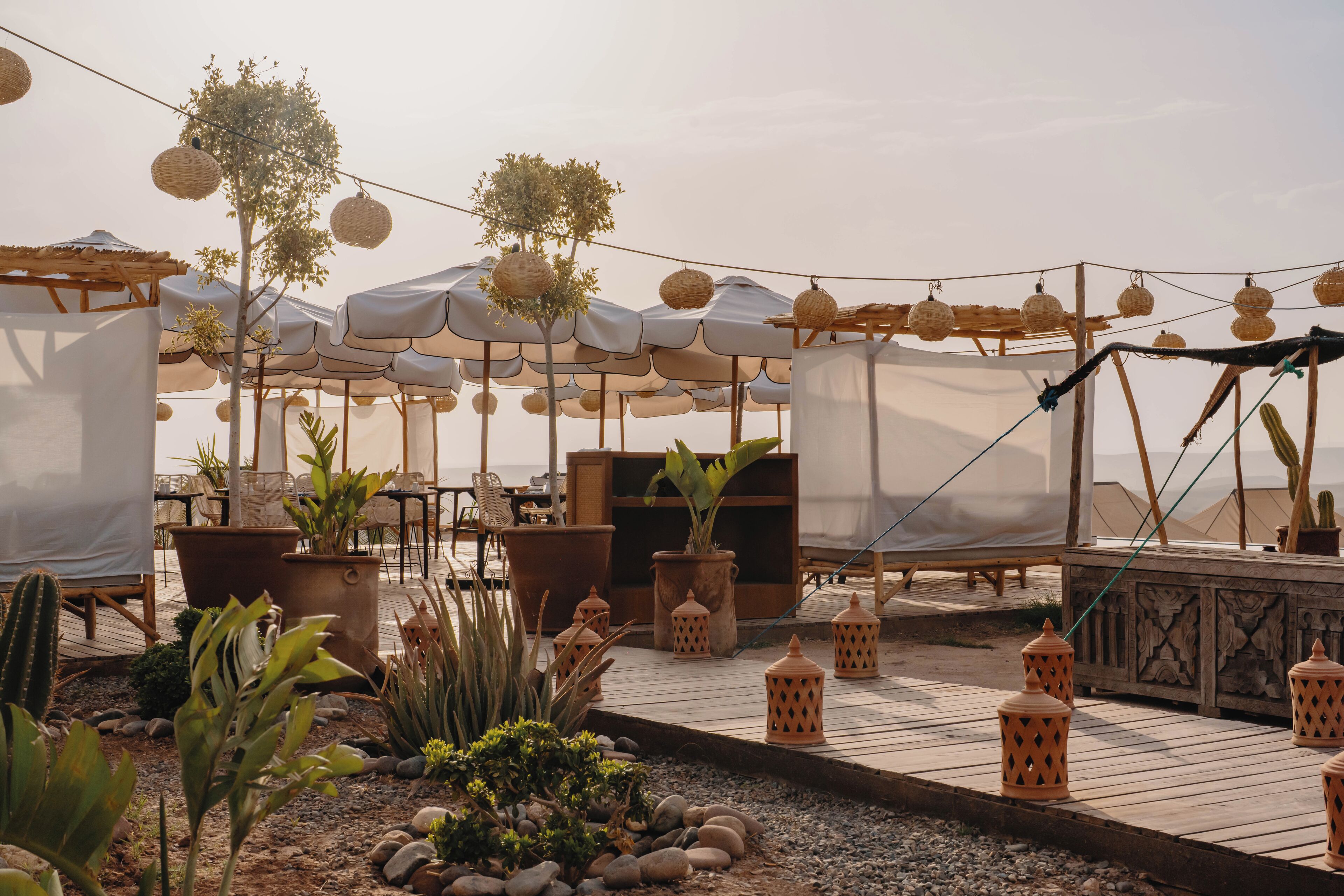 An outdoor seating area with tables, chairs, and umbrellas.