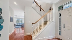 A staircase with white railings and wooden steps leading to a door with a glass panel. - Relax and recharge in comfort at this stylish Heritage Village retreat! (Lewes)