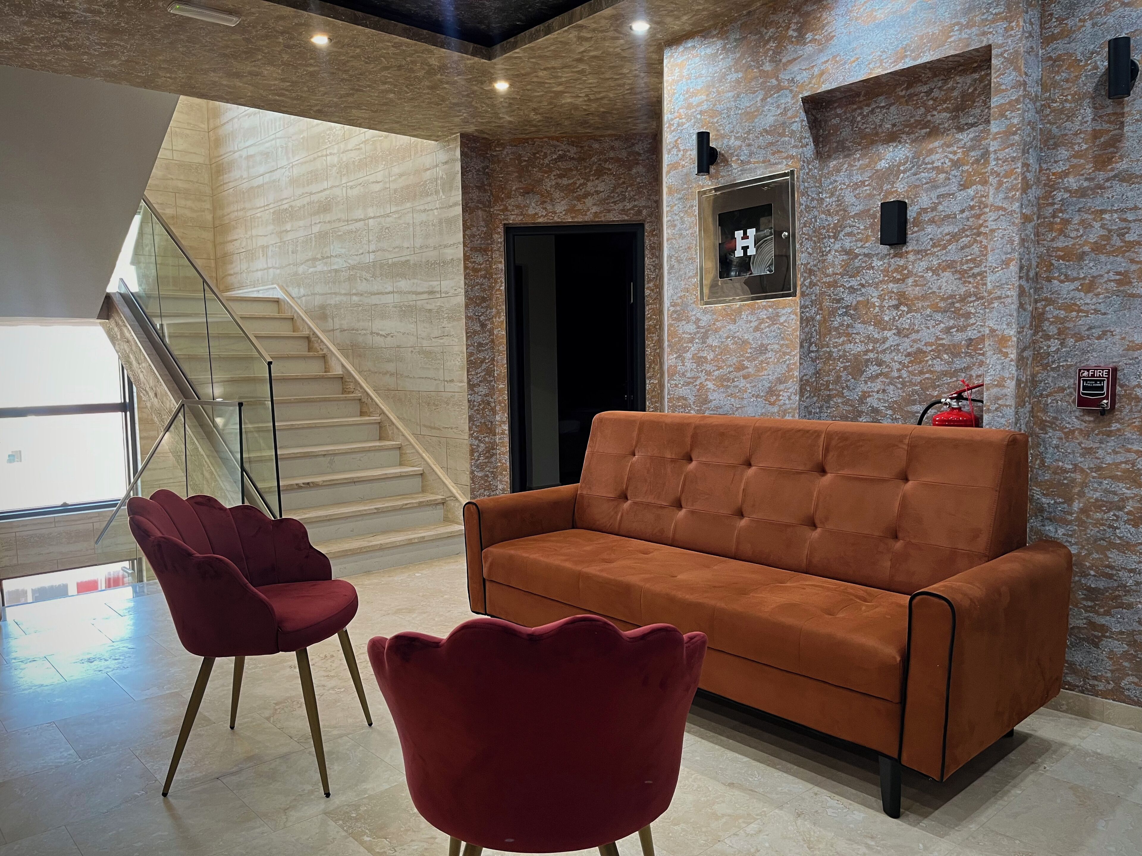 Um interior moderno com uma escada, um sofá e uma cadeira vermelha.